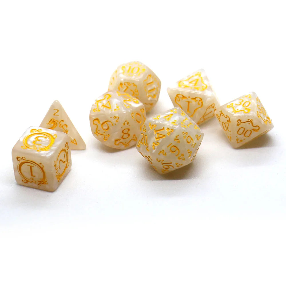 A set of ten dragon-embellished polyhedral dice in a pale yellow or ivory color scattered on a white surface.