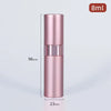 A tall, cylindrical pink aluminum perfume atomizer with a silver cap and a black measuring line visible.