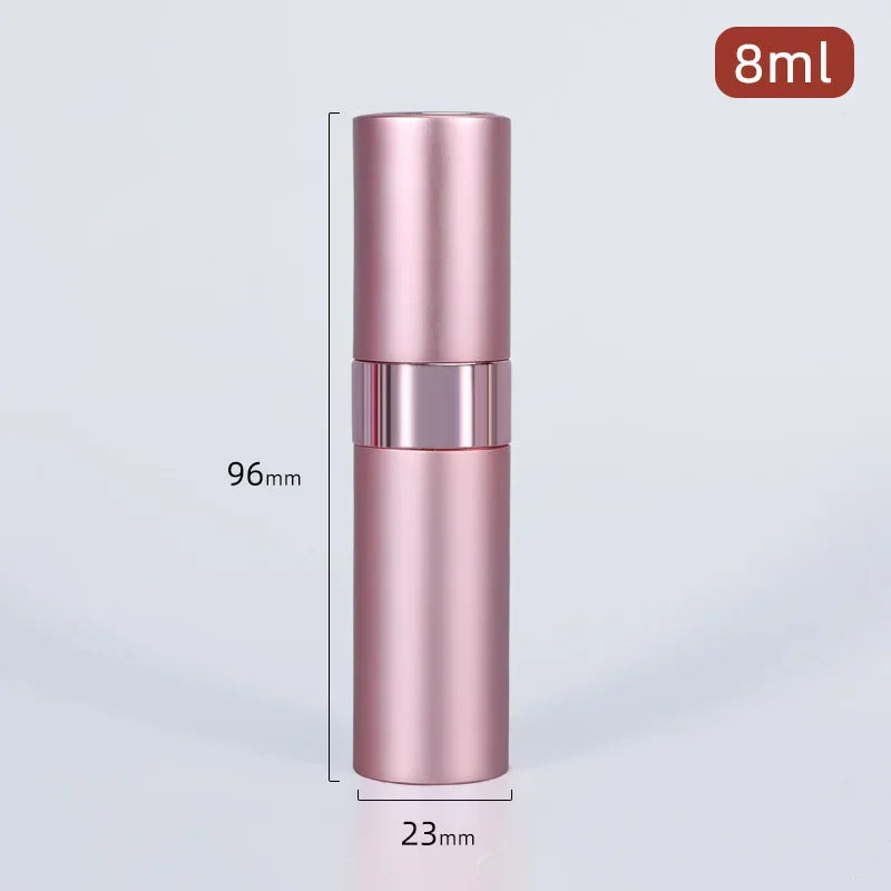 A tall, cylindrical pink aluminum perfume atomizer with a silver cap and a black measuring line visible.