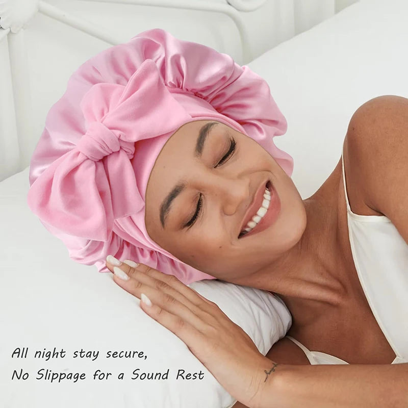 A woman is sleeping peacefully wearing a pink satin sleeping bonnet.
