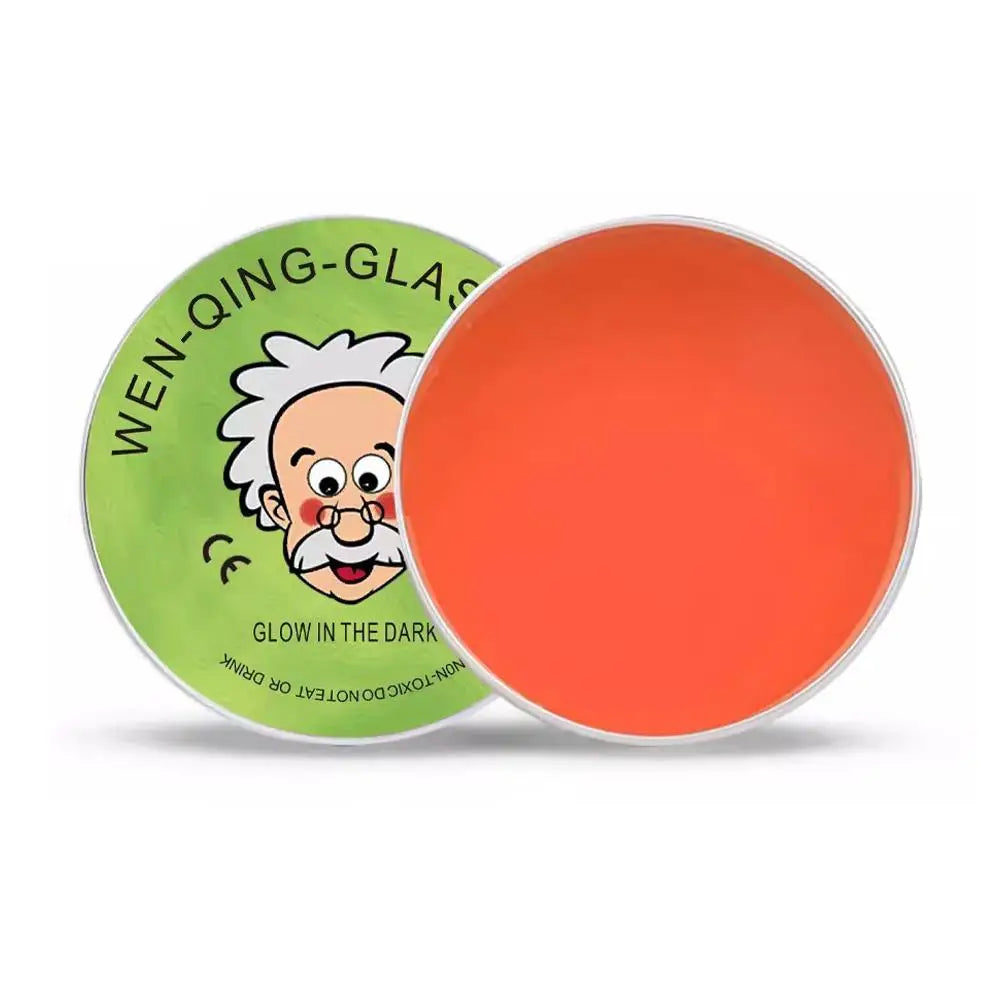 A round orange putty in a green tin featuring a cartoon man and text that reads Glow in the Dark