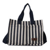 A striped canvas tote bag with black and beige vertical stripes and black handles.