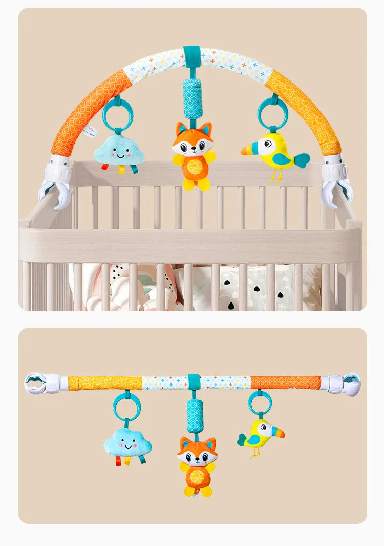 A baby stroller arch toy featuring orange and white arms with hanging plush charms of a blue cloud, an orange fox, and a yell