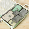 A light green packing cube set with six zippered pouches is displayed inside the open storage box.
