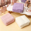 A collection of purple and pink fabric pouches for storing cosmetics and sanitary napkins on a white surface.