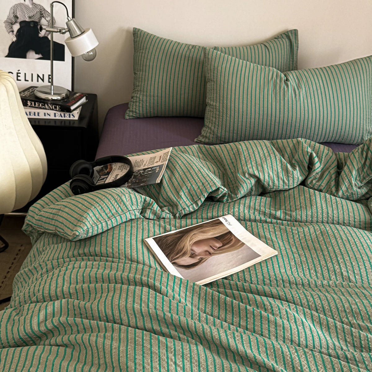 A green and white striped duvet cover set with matching pillows on a bed.