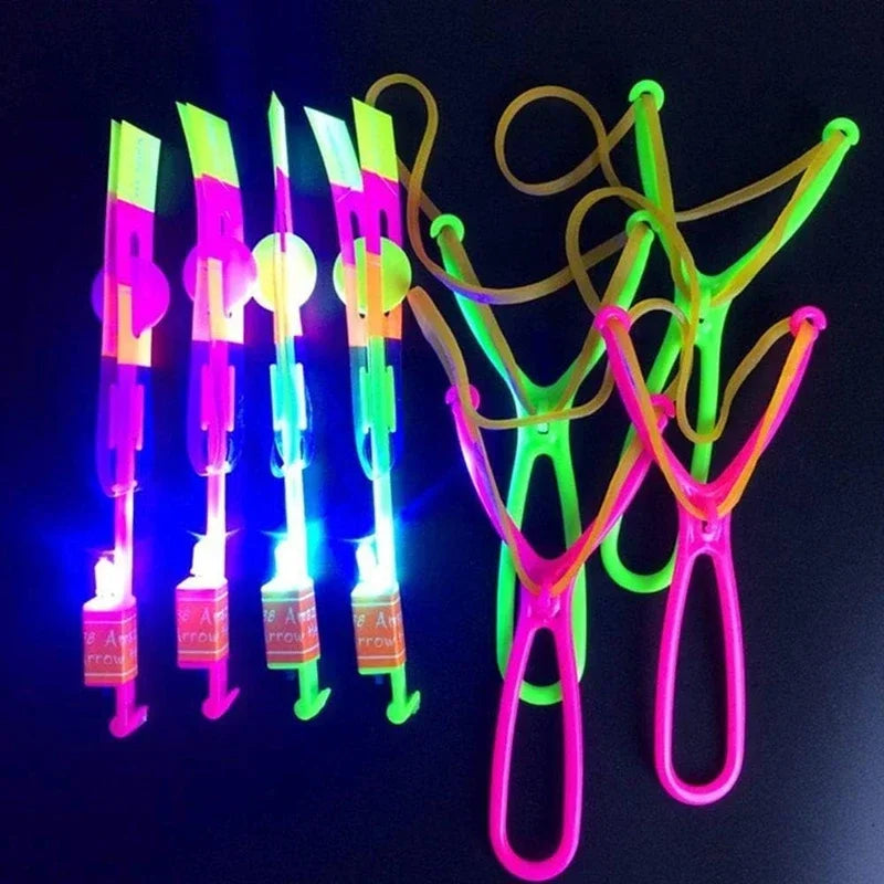 A collection of LED glowing flying arrow toys with rubber band launchers in various bright colors.