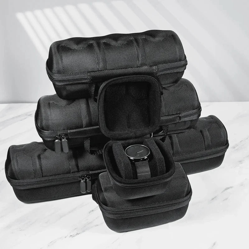 A stack of black portable leather watch travel cases with soft lining displayed on a white marble surface.