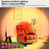 A comfortable armchair is illuminated by a rainbow gradient lighting effect in a room.