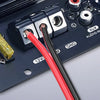 Nahaufnahme eines dunklen elektronischen Geräts mit Anschlüssen, einer Sicherungshalterung und einem Audioeingangsockel.