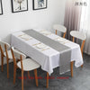 Elegant satin gray table runner displayed on a white tablecloth in a bright room.