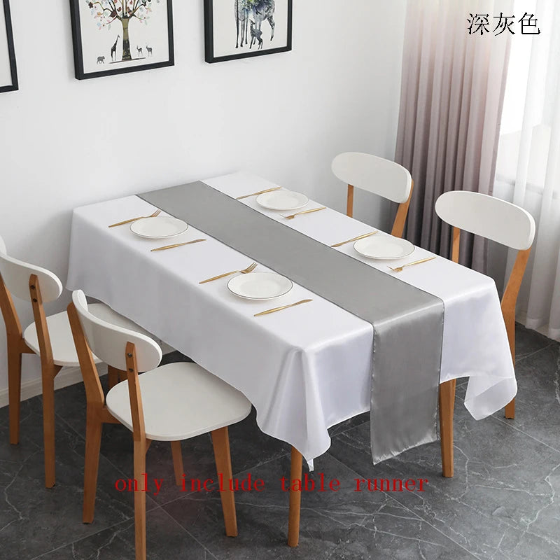 Elegant satin gray table runner displayed on a white tablecloth in a bright room.