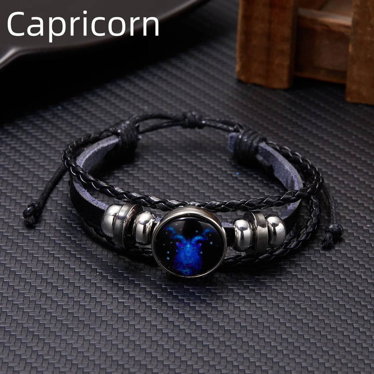 A black leather wrap bracelet featuring a blue glow charm and silver accents.