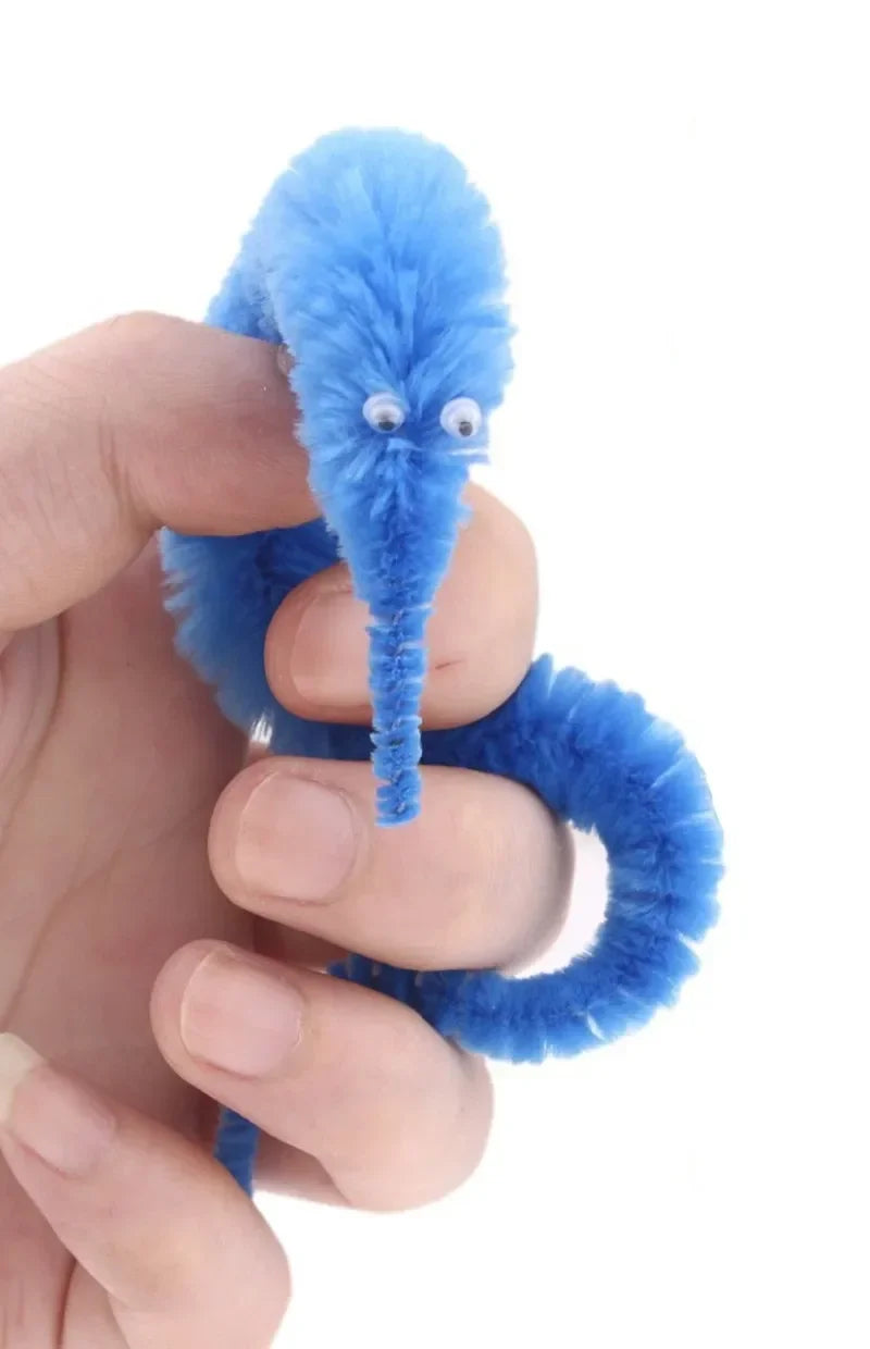A hand holds a bright blue, fuzzy caterpillar trick with large eyes.