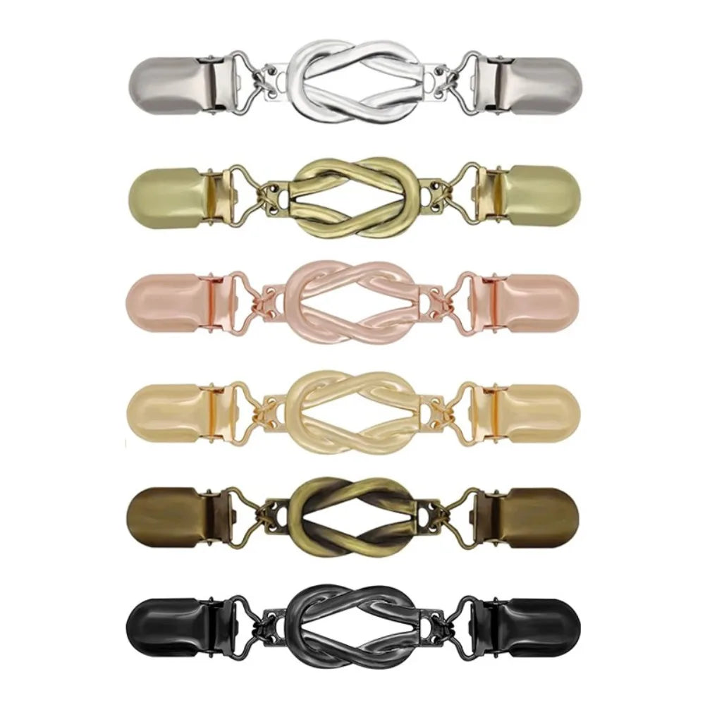 A set of vintage metal shawl and sweater clips in various colors including silver, gold, pink, beige, and black.