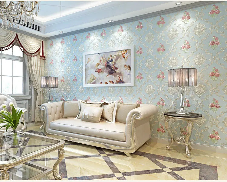 Elegant living room featuring a light blue floral wallpaper, a sofa, and decorative glass tables.
