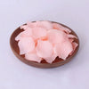 A bowl filled with pink silk rose petals for weddings and proposals.