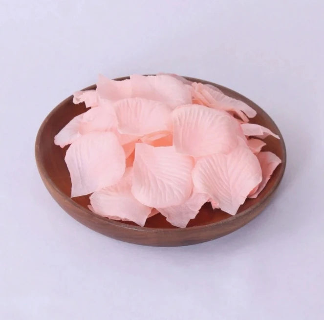 A bowl filled with pink silk rose petals for weddings and proposals.