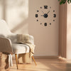 A modern living room features a light-colored armchair next to a wall clock with black numbers and hands.
