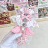 A hand holds a pink and white decorative cat paw shaped utility cutter with a glittery bow and heart detail.