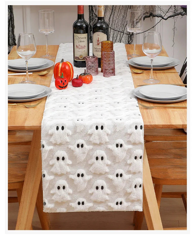 A white table runner with a ghost pattern is set on a wooden table for an autumn or Halloween meal.
