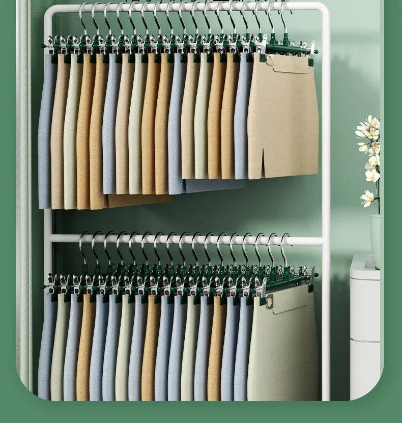 A set of five anti-slip stainless steel hangers with clips for pants and skirts displayed in a white rack.