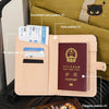 A light pink pu leather passport holder with multiple card slots and a passport visible inside.