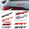 A collection of metal SRT grille emblems and stickers in various colors including silver, black, and red.