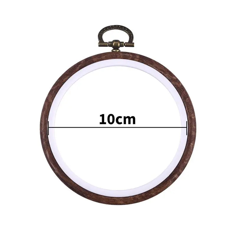 A round wooden embroidery hoop with a metal clamp, used for cross-stitch and needlework.