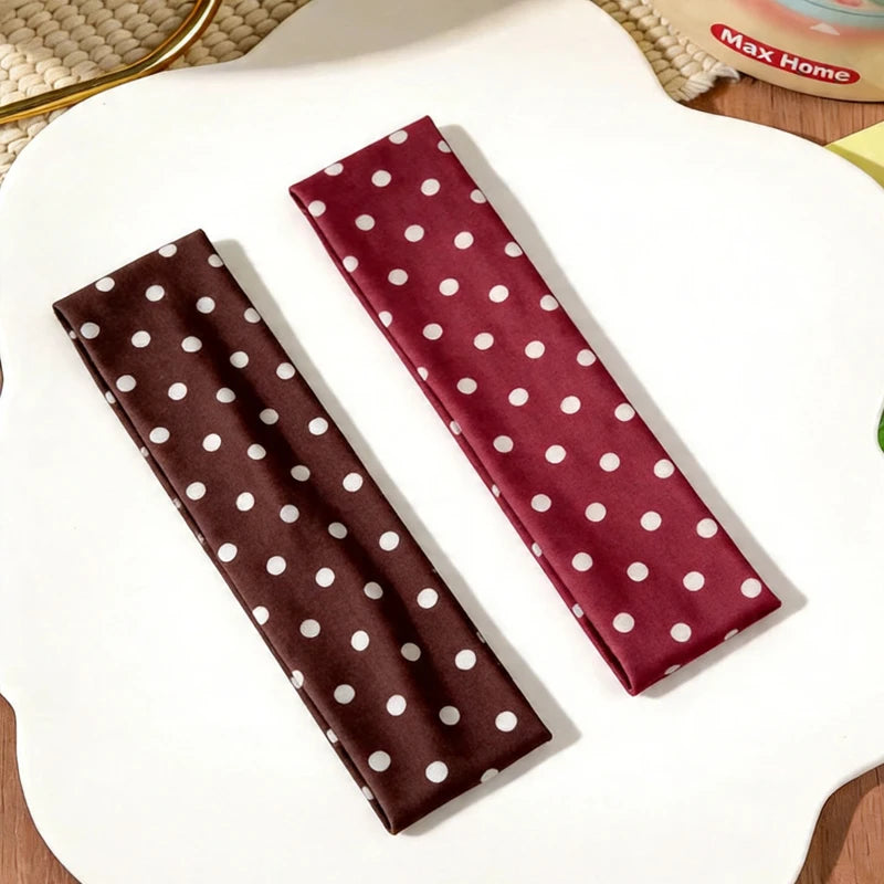 Un bandeau en tissu marron à pois blancs est exposé sur une assiette blanche.