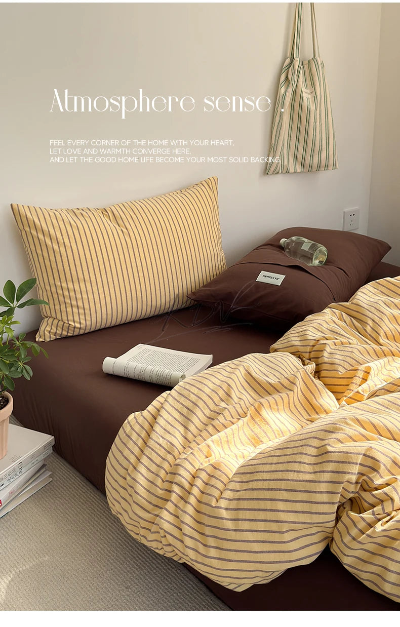A set of mustard yellow and beige striped bedding, including a pillow and duvet cover, displayed on a bed.