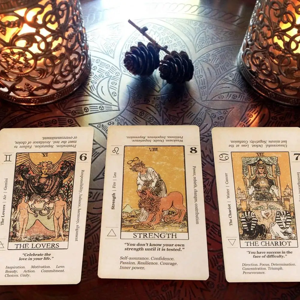 A spread of tarot cards showing The Lovers, Strength, and The Chariot with detailed illustrations.