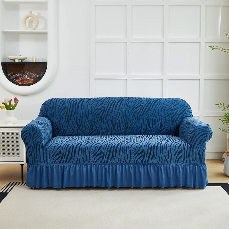 A deep blue zebra print sofa cover with an elastic skirt displayed on a light-colored rug.