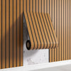 A close-up of a wooden peel-and-stick wall panel installed on a vertical wood slat background.