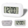A white compact LED digital alarm clock with a display showing 12:00, featuring separate buttons for set mode and day/date.