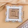 A rectangular switch cover frame with a rose pattern border and a brown electrical outlet inside.