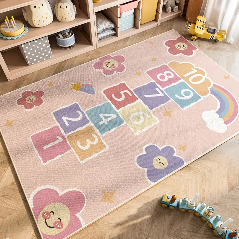 A pink and yellow play mat featuring colorful numbers, shapes, and a rainbow for kids.
