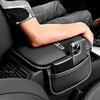 A hand rests on a black car armrest box mat with a storage pocket for an Audi vehicle interior.