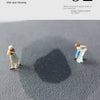 A dark shadow is cast on a gray floor by small figures, demonstrating the water absorption of the mat.