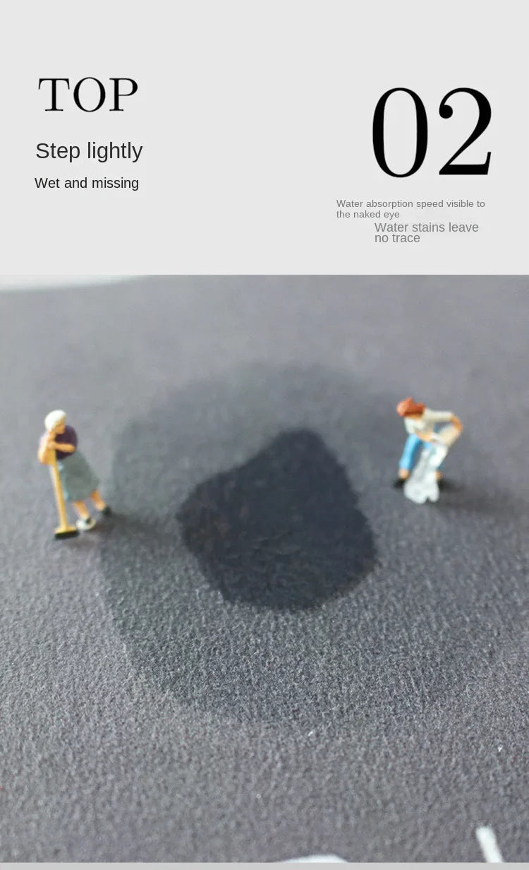 A dark shadow is cast on a gray floor by small figures, demonstrating the water absorption of the mat.