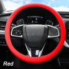 A red silicone steering wheel cover is shown inside a car's interior, featuring a modern steering wheel and dashboard visible