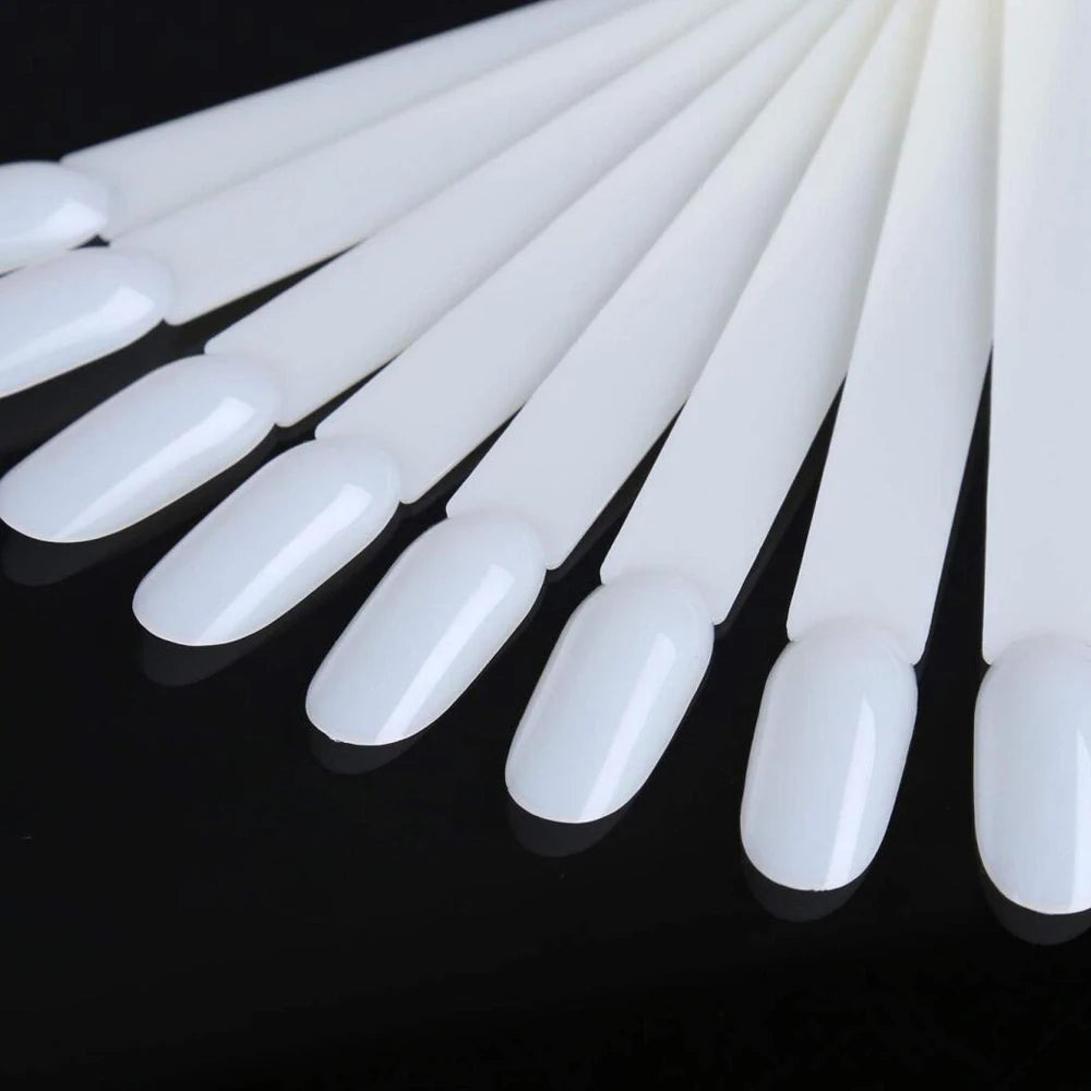 A set of clear acrylic false nail tips for practice and display, arranged in a row.