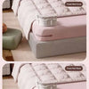 Close-up of a pink bed sheet fastened together using white non-slip clips on a bed.