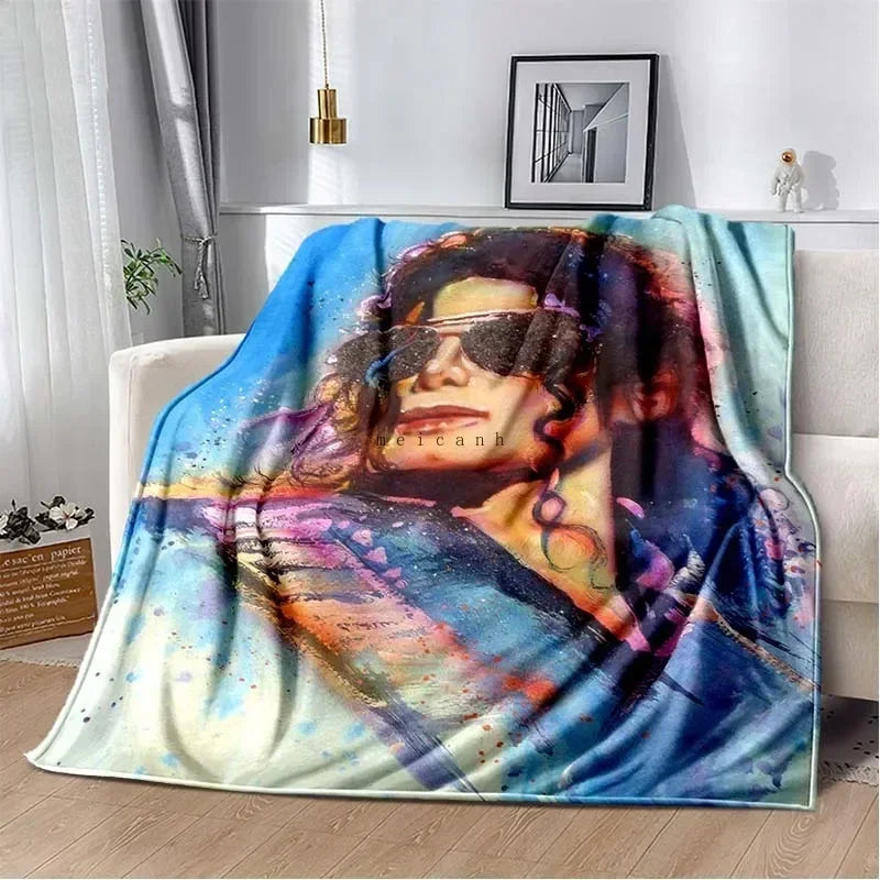 A colorful print of Michael Jackson on a flannel throw blanket draped over a sofa.
