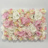 A dense wall panel of pink and white silk rose flowers for weddings and events.