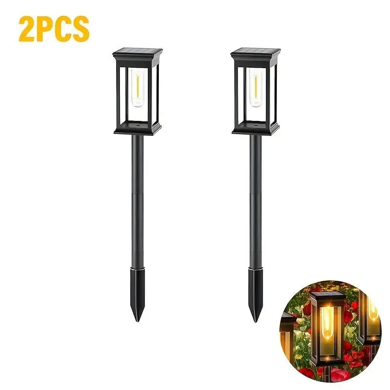 Two black solar path lights with warm glow bulbs shown against a white background.