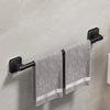 A black wall-mounted towel rack holding a gray towel with white stripes.