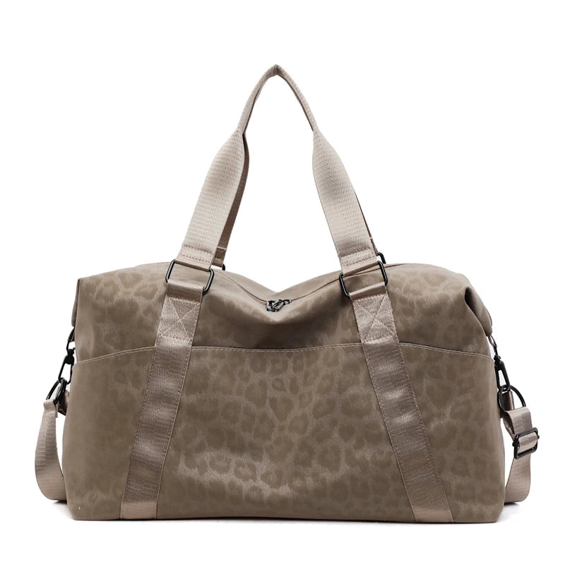 A taupe leopard print duffle bag with adjustable straps.