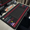 A black mechanical mouse pad featuring a grid pattern and various control buttons for gaming, resting on a wooden desk.
