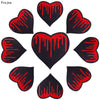 A set of ten black heart-shaped iron-on patches with red dripping designs.